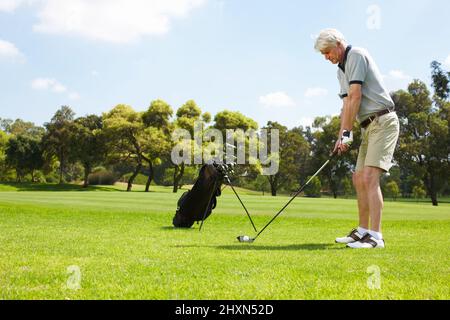 Seine Haltung genau richtig zu machen Älterer Mann, der sich auf den Golfplatz vorbereitet. Stockfoto