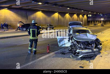 Stuttgart, Deutschland. 13. März 2022. Neben einem der am Unfall beteiligten Fahrzeuge auf der B 14 in der Unterführung Charlottenplatz steht ein Feuerwehrmann. Eine schwer verletzte und eine leicht verletzte Person sind die Folgen eines Verkehrsunfalls, der sich nach Angaben der Polizei am Sonntagabend auf der B 14 in der Stuttgarter Unterführung Charlottenplatz ereignete. Quelle: Schulz/SDMG/dpa/Alamy Live News Stockfoto