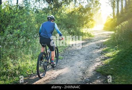 Männlicher Radfahrer, der mit dem Mountainbike auf einem ländlichen Bergpfad unterwegs ist Stockfoto