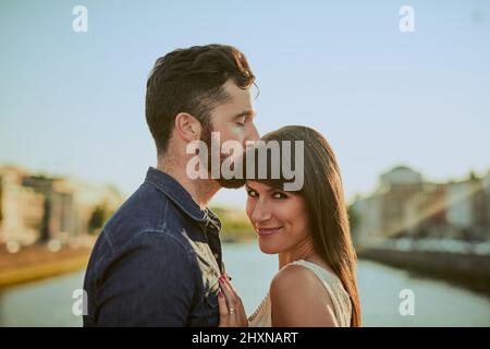 Hes my everything. Kurzer Schuss eines hübschen jungen Mannes, der seine Freundin auf die Stirn küsst, während er sich auf einem Date befindet. Stockfoto