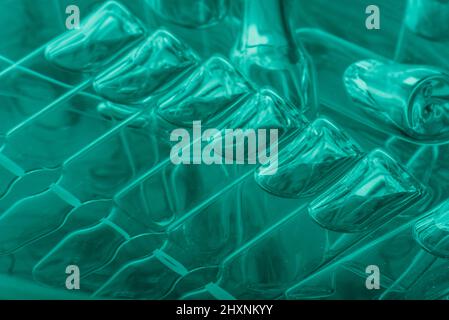 Medizinische Ampullen aus Glas zur Injektion. Medizin ist flüssiges Natriumchlorid mit wässriger Lösung in Ampulla. Nahaufnahme. Flaschen Ampulle Multicolor auf Hintergrundfarbe und Wasser. Humanplasma. Stockfoto