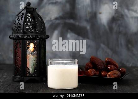 Susu Kurma oder Datteln Fruchtglättung aus Milch und Datteln Palmenfrüchte, auf Holzhintergrund mit Ramadan Konzept Laterne Stockfoto