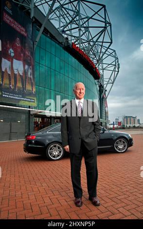 Sir Bobby Charlton mit seinem Audi A6 auf dem Manchester United Fußballplatz Old Trafford UK Stockfoto