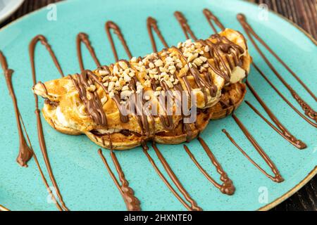 Sandwich-Waffeln mit Banane, Erdbeere und Schokolade und Pistazie auf der Oberseite Stockfoto