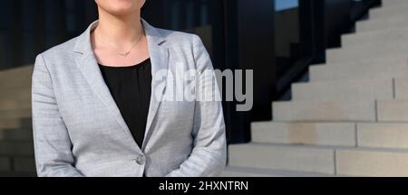 Weibliche Profi in einem schwarzen Hemd und einer grauen Anzugjacke Stockfoto