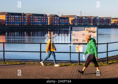 Preston, Lancashire. Großbritannien, 13. März 2022. In den Docklands beginnt der Tag bei klarem Sonnenschein, während die Anwohner einen morgendlichen Spaziergang durch den Yachthafen Unternehmen. Quelle: MediaWorldImages/AlamyLiveNews Stockfoto