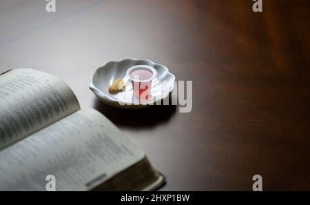 Christliches Abendmahl Sakramente, Wein und Brot mit offener Bibel. Stockfoto