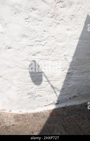 Enge Gasse in Chora auf der Insel Patmos mit Lampenschatten an weiß gewaschenen Wänden Stockfoto