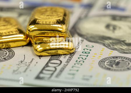 Stapel von reinen Goldbarren, Goldbarren, Barren auf dem Hintergrund von US-Dollar-Banknoten Stockfoto