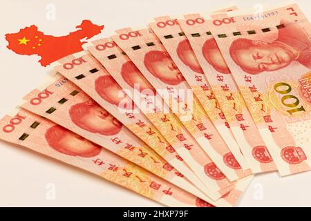 Renminbi oder RMB, CNY, Währung von China. Set von einhundert Yuan aus der Nähe. Chinesisches Geld. Geschäftskonzept. China-Karte und Nationalflagge auf weißem Rücken Stockfoto