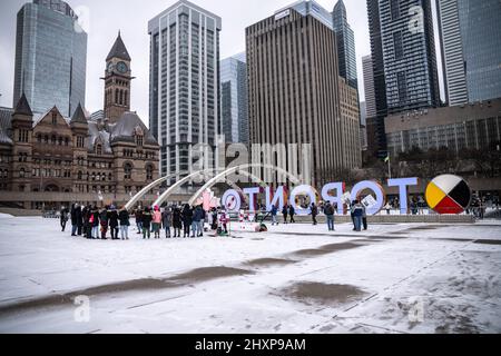 Toronto, Kanada. 13. März 2022. Die Protestierenden sahen, wie sie sich während der Kundgebung „Live With No Fear“ der Frauen vor einem „Toronto“-Schild versammelten. Frauen organisieren einen feministischen marsch, um Gerechtigkeit zu fordern und Gewalt gegen lateinamerikanische Frauen vor dem Rathaus in Toronto sichtbar zu machen. Kredit: SOPA Images Limited/Alamy Live Nachrichten Stockfoto