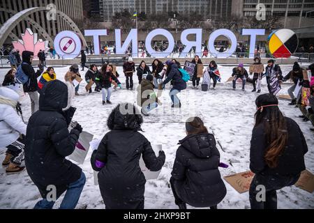 Toronto, Kanada. 13. März 2022. Während der Kundgebung „Live With No Fear“ der Frauen sahen die Demonstranten, wie sie im Kreis vor einem „Toronto“-Schild tanzten. Frauen organisieren einen feministischen marsch, um Gerechtigkeit zu fordern und Gewalt gegen lateinamerikanische Frauen vor dem Rathaus in Toronto sichtbar zu machen. Kredit: SOPA Images Limited/Alamy Live Nachrichten Stockfoto