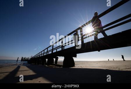 03. März 2022, Schleswig-Holstein, Föhr: Bei strahlendem Sonnenschein sind Wanderer auf einer Anlegestelle in Wyk auf der Nordseeinsel Föhr. Foto: Christian Charisius/dpa Stockfoto