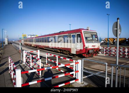 03. März 2022, Schleswig-Holstein, Dagebüll: Ein Triebwagen der Norddeutschen Eisenbahn Niebüll GmbH (NEG) verlässt den Hafen von Dagebüll neben der Fähre Schleswig-Holstein der Wyker Dampfschiffs-Reederei (WDR). Foto: Christian Charisius/dpa Stockfoto