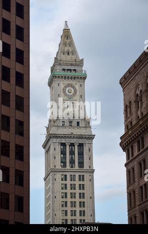 Blick auf den Uhrenturm des Zollbüros von Boston zwischen zwei Hochhäusern bei bewölktem Wetter Stockfoto