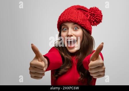 Girl Shows mögen die Kamera, tragen einen Neujahrshut, konzentrieren sich auf das Gesicht Stockfoto