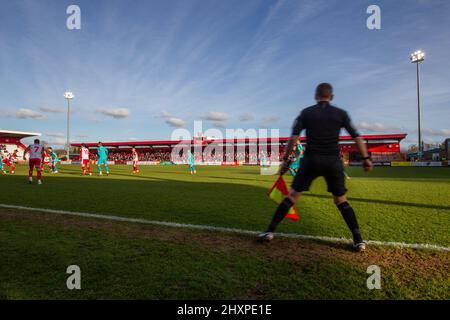 Schiedsrichter-Assistent / Linesman läuft die Linie bei einem Fußballspiel. Lamex Stadium, Stevenage >Hertfordshire an sonnigen Tagen Stockfoto