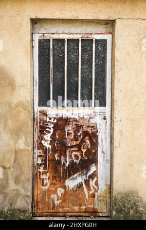 Alicante, Spanien- 4. Februar 2022:Aluminiumtür mit geometrischen Details und Graffiti-Gemälden Stockfoto