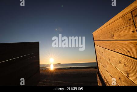 Utersum, Deutschland. 03. März 2022. Am Strandzugang von Utersum auf der Nordseeinsel Föhr geht die Sonne über der Nordsee unter. Quelle: Christian Charisius/dpa/Alamy Live News Stockfoto