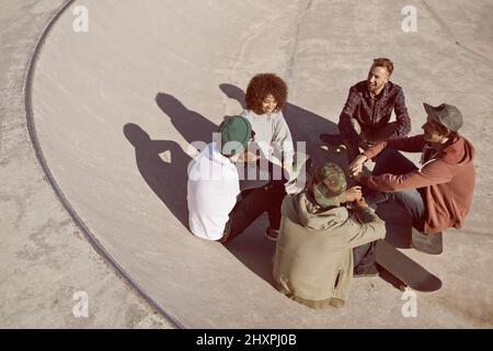 Einer der Jungs. Aufnahme einer Gruppe von Freunden, die in einem Skatepark in der Sonne hängen. Stockfoto