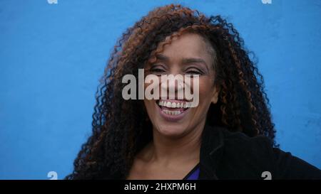 Eine glückliche latina hispanische schwarze Frau lachend und lächelnd Portrait Gesicht Stockfoto