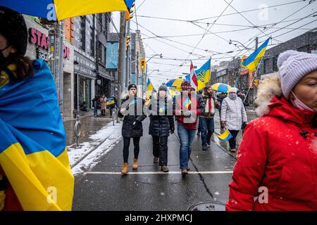 Toronto, Kanada. 13. März 2022. Während der Demonstration marschieren die Demonstranten mit ukrainischen Fahnen. Tausende marschieren zum US-Konsulat zu einer „No Fly Zone“-Kundgebung in Toronto, Kanada. Nach dem russischen Einmarsch in die Ukraine wurden weltweit Proteste organisiert. Kredit: SOPA Images Limited/Alamy Live Nachrichten Stockfoto