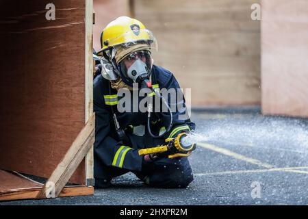 Quezon City. 14. März 2022. Eine Feuerwehrfrau nimmt am 14. März 2022 an den Olympischen Spielen für die Fähigkeiten der Feuerwehrfrauen im philippinischen Büro für Brandschutz-National Capital Region (BFP-NCR) in Quezon City, Philippinen, Teil. Das philippinische Bureau of Fire Protection (BFP) veranstaltete im Rahmen der Einhaltung des National Women's Month und des Fire Prevention Month die Olympischen Spiele für Feuerwehrmänner, um die Fähigkeiten ihrer weiblichen Mitarbeiter in den Bereichen Feuerlöschung, Notfallreaktion und Rettungsfähigkeiten unter Beweis zu stellen. Quelle: Rouelle Umali/Xinhua/Alamy Live News Stockfoto