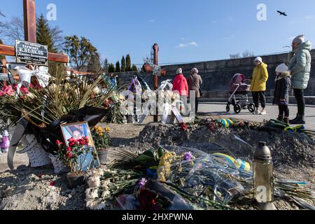 Vulka, Ukraine. 13. März 2022. Familien, die um ihre Angehörigen trauern, die in der aktuellen Kriegskrise auf dem Lychakiv-Friedhof getötet wurden. Trotz der internationalen Verurteilung der russischen Invasion steigt die Zahl der Todesopfer in der Kriegskrise weiter an, wie der ukrainische Präsident Wolodymyr Zelenskyy sagte, dass bei der Aktion am Samstag, dem 12. März 2022, 1.300 Soldaten getötet wurden. Kredit: SOPA Images Limited/Alamy Live Nachrichten Stockfoto