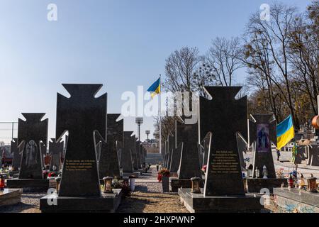 Vulka, Ukraine. 13. März 2022. Grabsteine ukrainischer Soldaten, die 2014 auf dem Lytschajiwer Friedhof verstorben sind. Trotz der internationalen Verurteilung der russischen Invasion steigt die Zahl der Todesopfer in der Kriegskrise weiter an, wie der ukrainische Präsident Wolodymyr Zelenskyy sagte, dass bei der Aktion am Samstag, dem 12. März 2022, 1.300 Soldaten getötet wurden. Kredit: SOPA Images Limited/Alamy Live Nachrichten Stockfoto