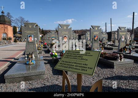 Vulka, Ukraine. 13. März 2022. Grabsteine ukrainischer Soldaten, die 2014 auf dem Lytschajiwer Friedhof verstorben sind. Trotz der internationalen Verurteilung der russischen Invasion steigt die Zahl der Todesopfer in der Kriegskrise weiter an, wie der ukrainische Präsident Wolodymyr Zelenskyy sagte, dass bei der Aktion am Samstag, dem 12. März 2022, 1.300 Soldaten getötet wurden. Kredit: SOPA Images Limited/Alamy Live Nachrichten Stockfoto