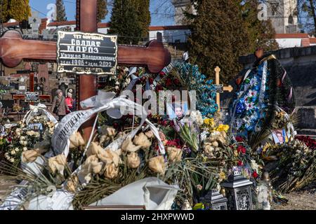 Vulka, Ukraine. 13. März 2022. Die Gräber ukrainischer Soldaten, die in der aktuellen Kriegskrise auf dem Lytschakiv-Friedhof getötet wurden. Trotz der internationalen Verurteilung der russischen Invasion steigt die Zahl der Todesopfer in der Kriegskrise weiter an, wie der ukrainische Präsident Wolodymyr Zelenskyy sagte, dass bei der Aktion am Samstag, dem 12. März 2022, 1.300 Soldaten getötet wurden. Kredit: SOPA Images Limited/Alamy Live Nachrichten Stockfoto