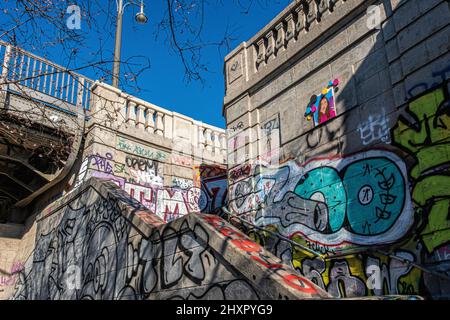 Graffiti-überdachte Treppen, die von der Straßenbrücke in der Bornholmer straße zum Norwegerstrassee, Prenzlauer Berg Berlin, Deutschland, führen Stockfoto