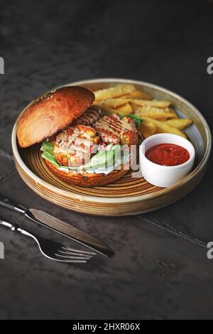 Falafel-Burger mit Salat, Tomaten, Zwiebeln, pommes frites, würzig duftender Sauce auf dem Tisch. Vegetarisches Essen lecker und nahrhaft. Platz für Text Stockfoto