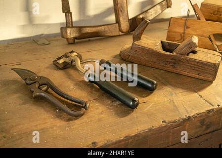 Detailaufnahme von historischen Metallwerkzeugen in einem Tisch Stockfoto