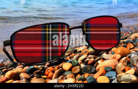 Gälische Tartan aus Rot, Weiß, Grün und Gelb, die auf Sonnengläsern aufgezwungen wird Stockfoto