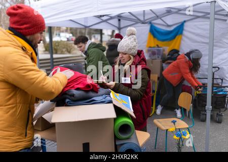 Freiwillige verteilen Spenden an Flüchtlinge an der ukrainischen Grenze, russisch-ukrainisches Kriegskonzept. Stockfoto