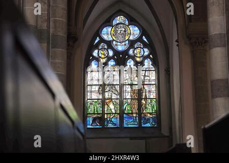 Köln, Deutschland. 14. März 2022. Licht fällt durch ein Kirchenfenster von Markus Lüpertz. Für St. Andreas, eine der zwölf romanischen Kirchen Kölns, hatte der Künstler bereits 2008 und 2010 zwölf Buntglasfenster entworfen. 2020 wurde das erste von insgesamt elf weiteren Fenstern nach seinen Entwürfen enthüllt. Jetzt wurden zwei weitere Fenster auf der Nordseite geschaffen. Quelle: Oliver Berg/dpa/Alamy Live News Stockfoto