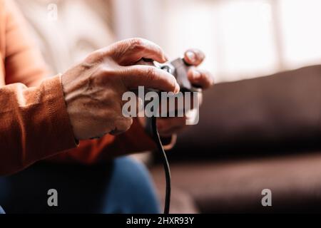 Nicht erkennbare Frau, die Videospielkonsole spielt. Stockfoto