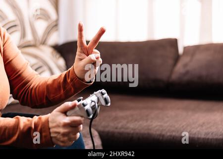 Nicht erkennbare Frau, die Videospielkonsole spielt. Stockfoto