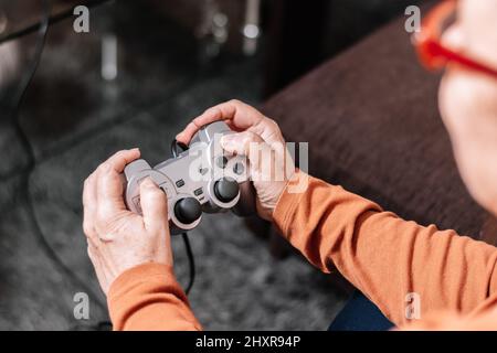 Nicht erkennbare Frau, die Videospielkonsole spielt. Stockfoto