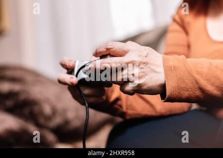 Nicht erkennbare Frau, die Videospielkonsole spielt. Stockfoto