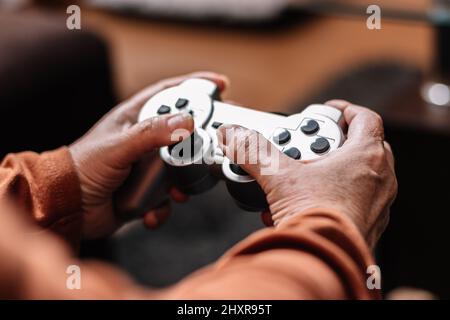 Nicht erkennbare Frau, die Videospielkonsole spielt. Stockfoto