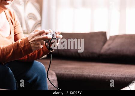 Nicht erkennbare Frau, die Videospielkonsole spielt. Stockfoto