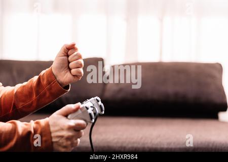 Nicht erkennbare Frau, die Videospielkonsole spielt. Stockfoto