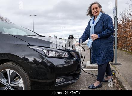 Ingliston Park & Ride, Edinburgh, Schottland, Großbritannien, 14. März 2022. Ingliston Park & Ride Elektroauto-Ladebuchten: Transport-Convener und Stadträtin der Stadt Edinburgh, Lesley MacInnes, sieht, wie neue Ladegeräte mit einem City of Edinburgh Council Elektroauto am Park and Ride funktionieren. Fünfzehn neue 7kwh Ladegeräte wurden installiert, um 30 weitere Elektrofahrzeuge als Teil der £2,2m-Einführung des Rates in der ganzen Stadt unterzubringen. Stockfoto