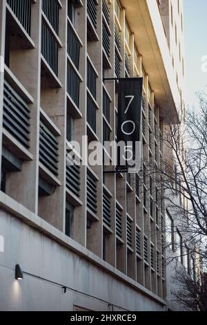 Vertikale Aufnahme eines Parkhauses, Gebäude mit Zahlen auf einem schwarzen Banner. Stockfoto