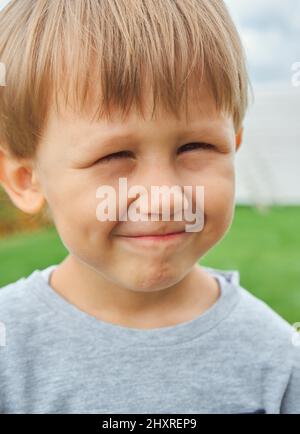 Glückliches Kind kleiner Junge 4 Jahre alt lächelnd im Freien, Blick auf die Kamera Stockfoto