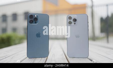 Moskau - Russland, 10.10.2021: Präsentation des neuen iPhone 13 Pro Max. Aktion. Konzept der neuen Technologien, zwei Smartphones stehen auf einer Bank im Freien. Stockfoto