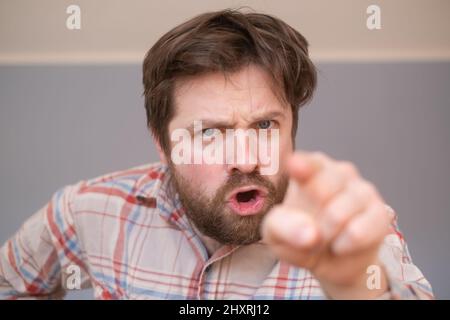 Junger, hübscher Mann mit Bart, der unzufrieden und frustriert auf die Kamera zeigt, wütend und wütend auf dich Stockfoto