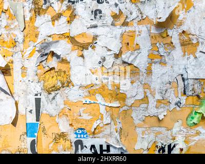 Plakatwand Mit Zerrissenem, Geschältem Poster, Abstrakter Hintergrund. Outdoor Bulletin Board Oder Sperrholztafel Mit Abgenutzten Werbemitteilungen, Mitteilungen Und Aufklebern Stockfoto